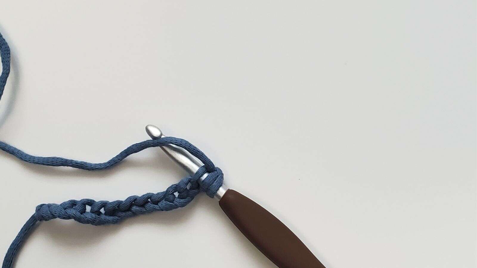 Yarn over your crochet hook after inserting the hook into the 2nd chain space
