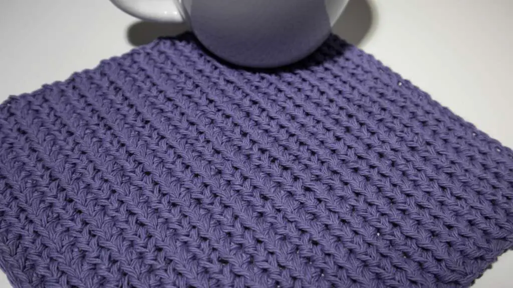 Whitley Crochet Dishcloth with a mug sitting on it