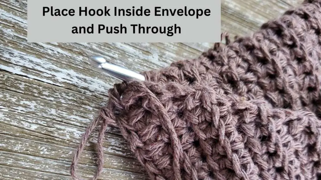 Taking hook from inside the envelope and pushing it through the corner to bring in thread